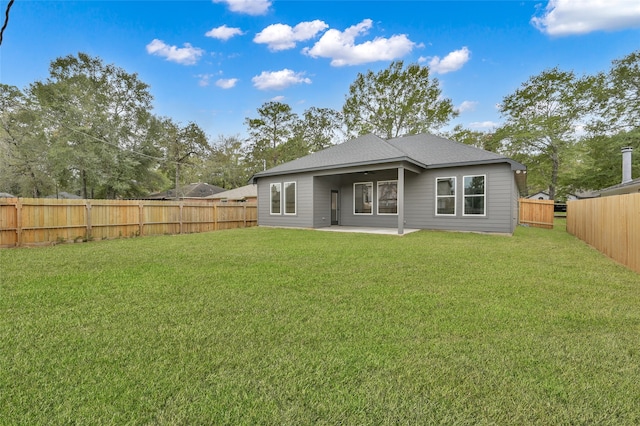 back of house with a patio and a lawn