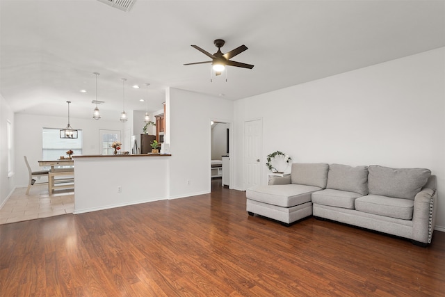 unfurnished living room with lofted ceiling, hardwood / wood-style flooring, and ceiling fan with notable chandelier