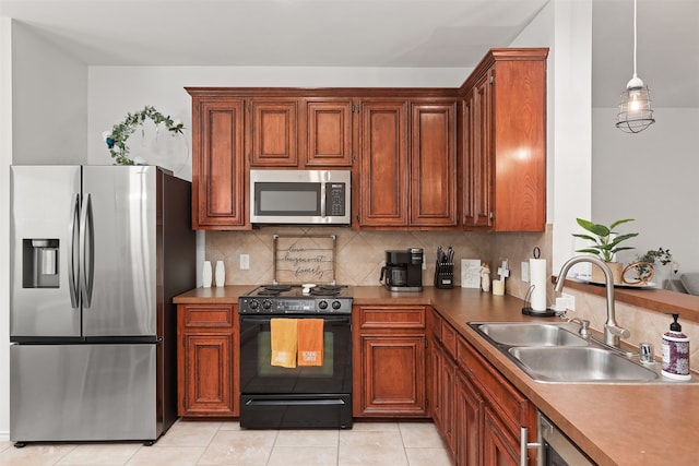 kitchen featuring backsplash, appliances with stainless steel finishes, light tile patterned flooring, pendant lighting, and sink