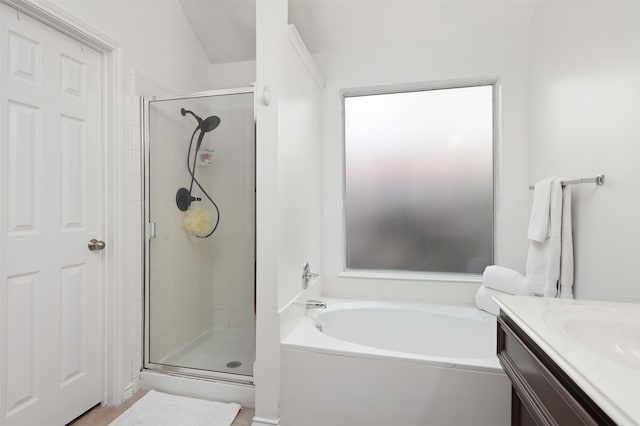 bathroom featuring vanity, shower with separate bathtub, and lofted ceiling