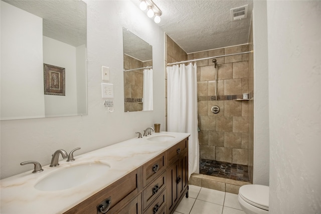 bathroom with a textured ceiling, a shower with shower curtain, toilet, vanity, and tile patterned flooring