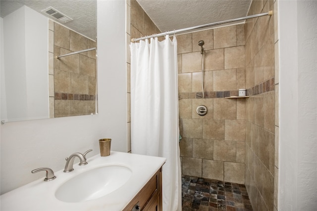 bathroom featuring vanity, a textured ceiling, and a shower with shower curtain