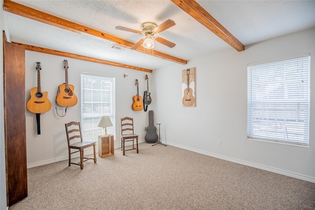 sitting room with beam ceiling, carpet flooring, and ceiling fan