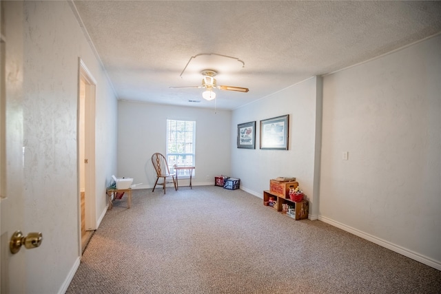 recreation room with carpet floors, a textured ceiling, and ceiling fan