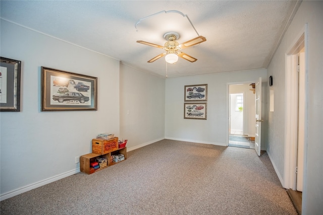 unfurnished room featuring a textured ceiling, carpet, and ceiling fan