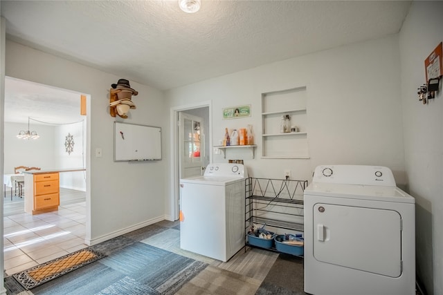 laundry room featuring light tile patterned floors, a textured ceiling, a chandelier, and separate washer and dryer