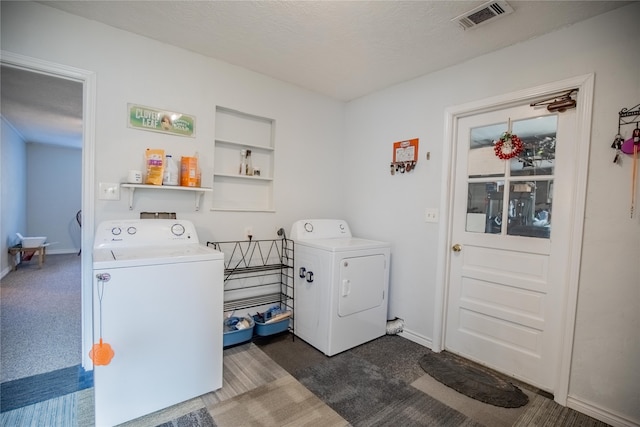 laundry room with built in features, a textured ceiling, separate washer and dryer, and dark carpet