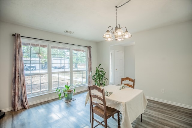 dining room with an inviting chandelier and dark wood-type flooring