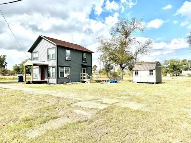 rear view of house with a yard and a storage shed