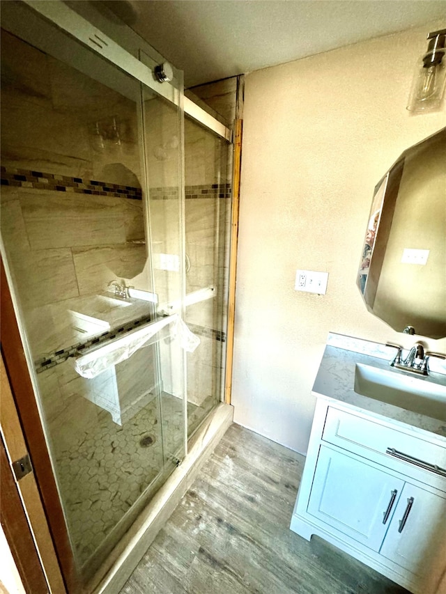 bathroom featuring vanity, wood-type flooring, and an enclosed shower