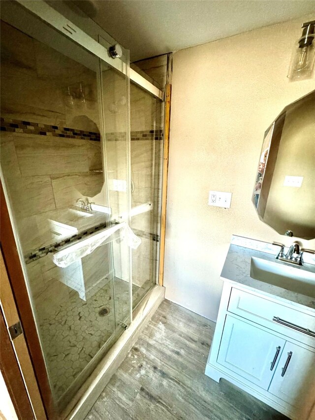 106 E Main St E, Wortham, TX 76693 - full bath with wood finished floors, a shower stall, and vanity