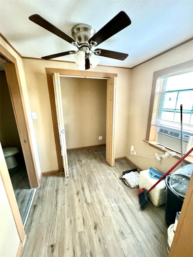106 E Main St E, Wortham, TX 76693 - unfurnished bedroom featuring light wood finished floors, a textured ceiling, a closet, baseboards, and ceiling fan