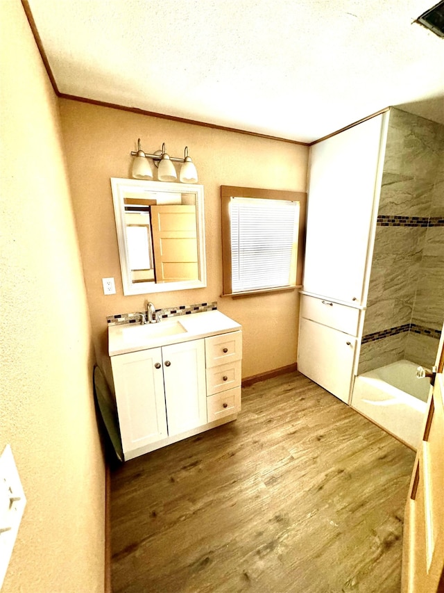 bathroom featuring hardwood / wood-style floors, crown molding, vanity, shower with separate bathtub, and a textured ceiling