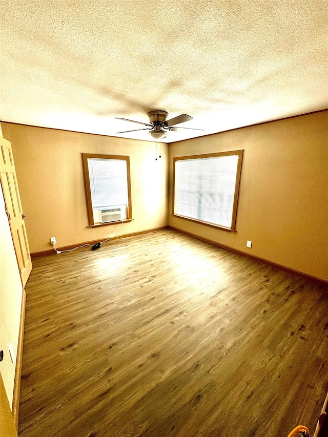 unfurnished room with cooling unit, hardwood / wood-style floors, a textured ceiling, and ceiling fan