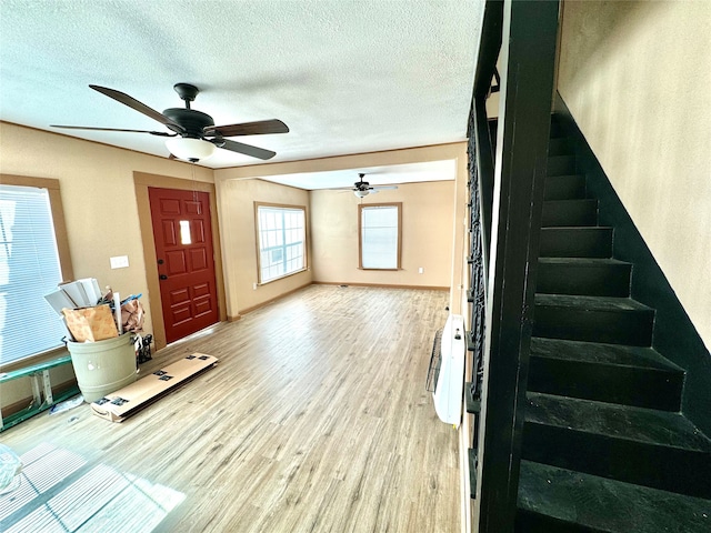 entrance foyer with a textured ceiling, wood-type flooring, and ceiling fan