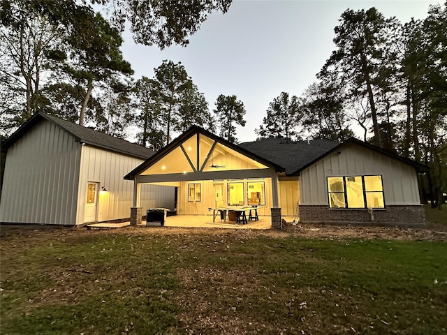 back of house with a yard and a patio