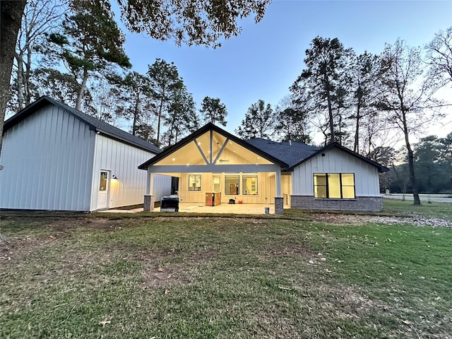 rear view of property featuring a lawn