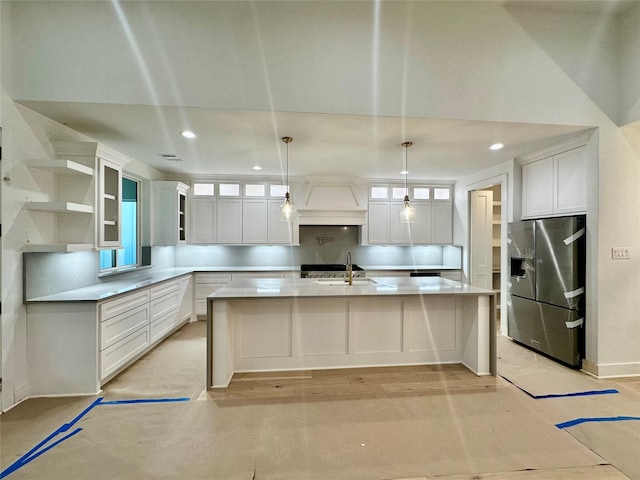 kitchen featuring sink, white cabinets, pendant lighting, and stainless steel refrigerator with ice dispenser