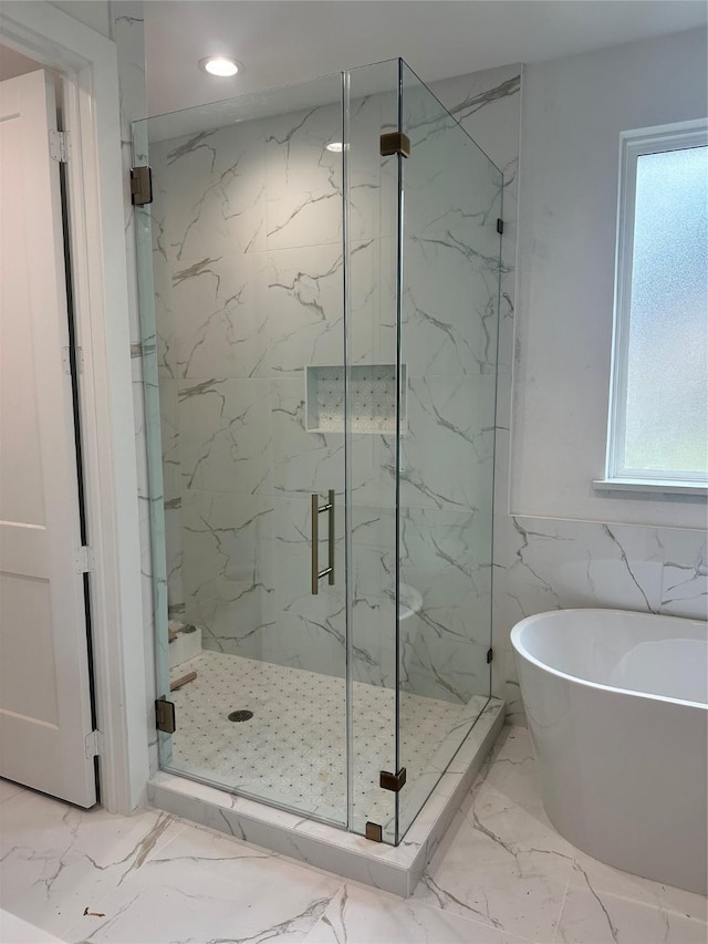 bathroom with tile walls and independent shower and bath