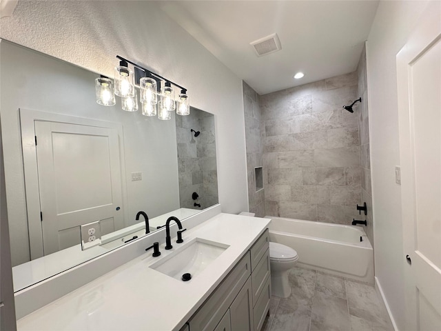 full bathroom with toilet, vanity, and tiled shower / bath