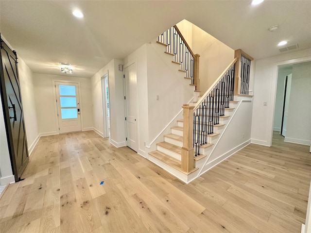 entryway featuring a barn door and light hardwood / wood-style flooring