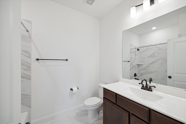 bathroom featuring tiled shower, toilet, and vanity