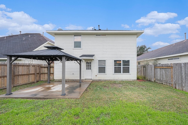 back of property with a lawn, a patio area, and a gazebo