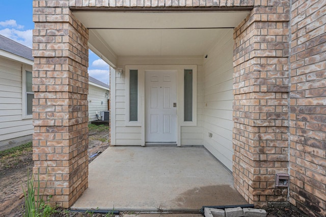 doorway to property with a patio and central AC