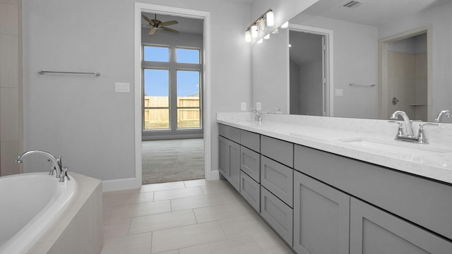 bathroom featuring a relaxing tiled tub, a sink, visible vents, tile patterned floors, and double vanity