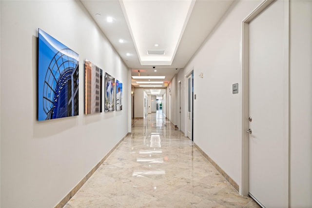 hallway with a raised ceiling