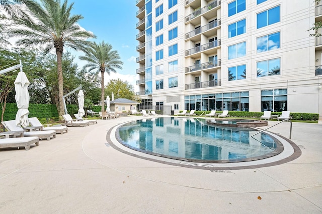 view of swimming pool with a hot tub