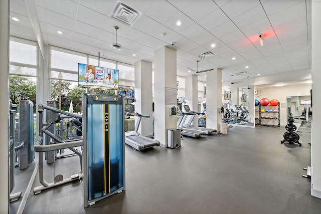 gym featuring floor to ceiling windows and a paneled ceiling