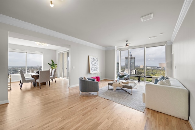 living room featuring a healthy amount of sunlight, light wood-type flooring, and crown molding