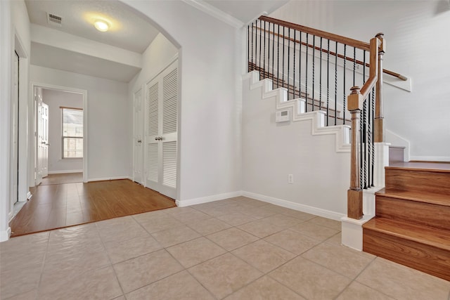 foyer with crown molding and light wood-type flooring