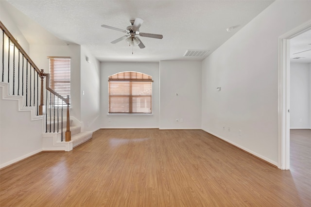 unfurnished living room featuring a textured ceiling, light hardwood / wood-style floors, and ceiling fan