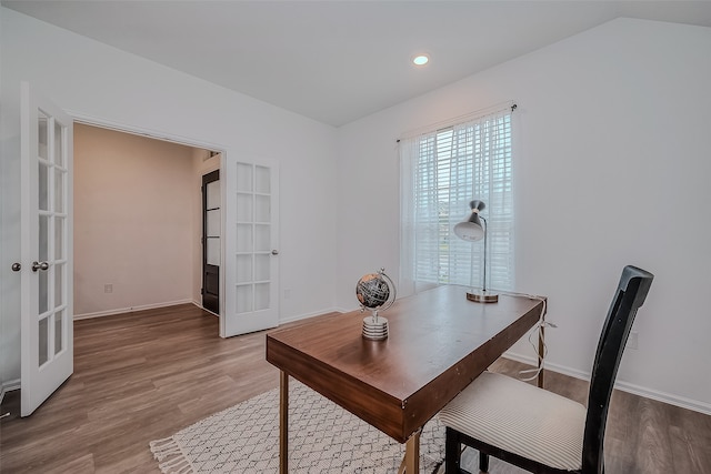 office area featuring french doors, hardwood / wood-style floors, and vaulted ceiling