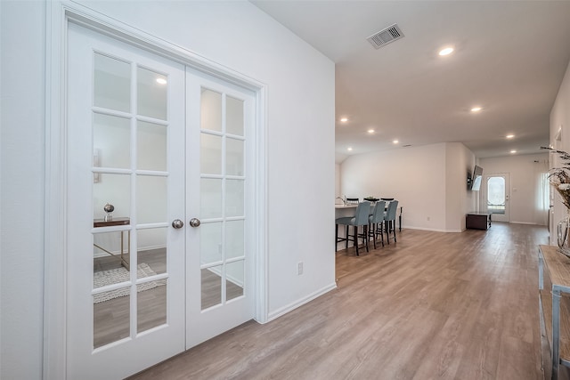 interior space with french doors and light hardwood / wood-style floors