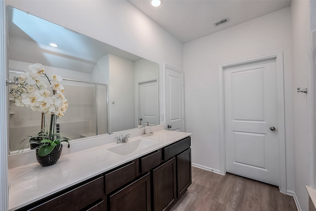 bathroom with a shower with door, vanity, and hardwood / wood-style floors