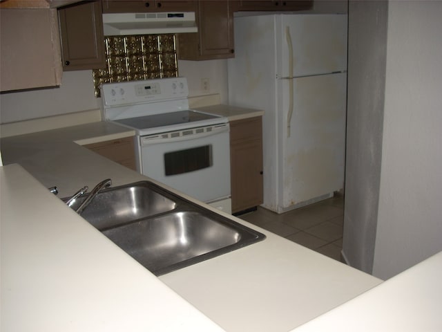 kitchen with sink, white appliances, and light tile patterned floors