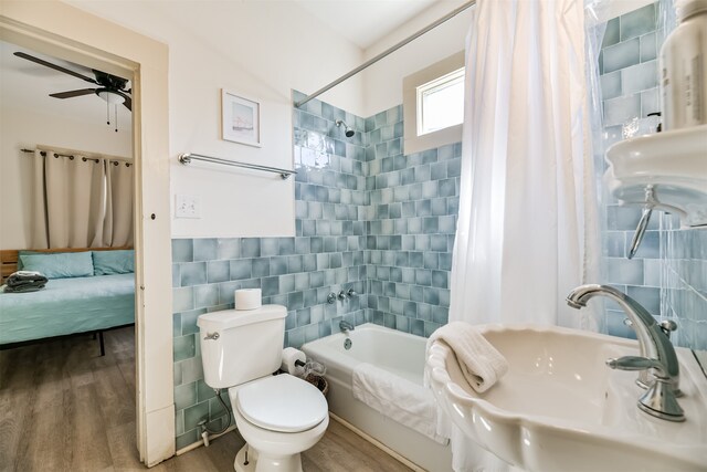 full bathroom with shower / bath combo, toilet, wood-type flooring, sink, and tile walls