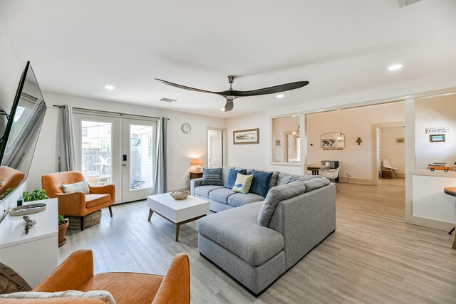 living room featuring french doors, ceiling fan, and light wood-type flooring