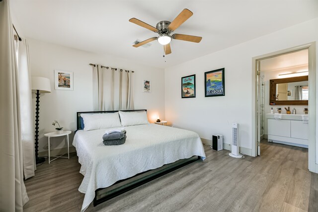 bedroom featuring ceiling fan, ensuite bathroom, and light hardwood / wood-style floors