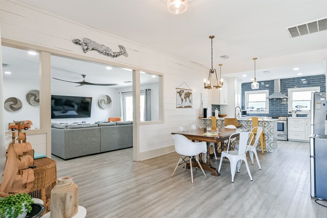 dining room with light hardwood / wood-style floors, a healthy amount of sunlight, sink, and ceiling fan