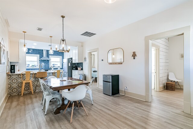 dining area featuring light hardwood / wood-style floors, a chandelier, and sink