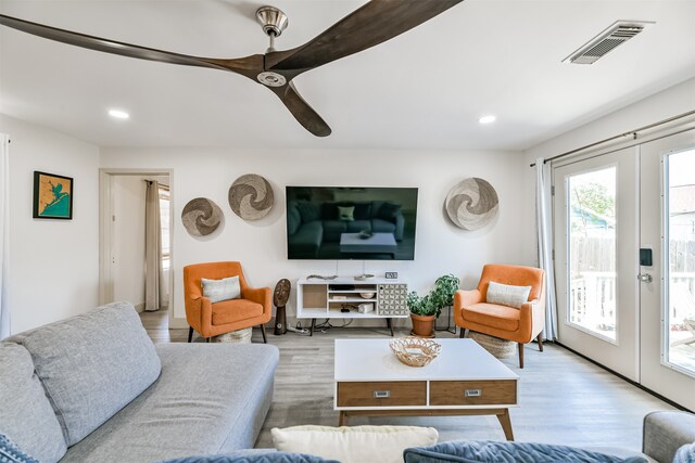 living room featuring french doors and light hardwood / wood-style flooring