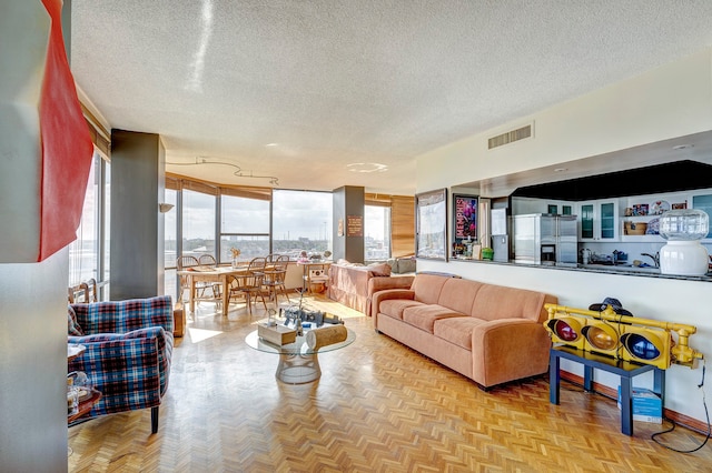 living room featuring a textured ceiling and light parquet flooring