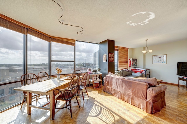 interior space with light parquet flooring, a notable chandelier, a textured ceiling, and expansive windows