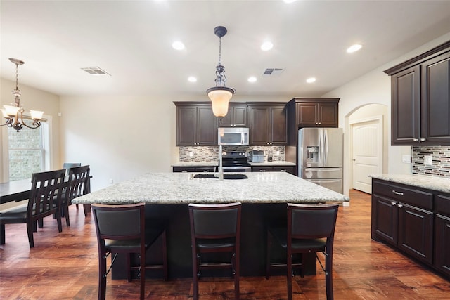 kitchen with a center island with sink, dark hardwood / wood-style flooring, sink, and appliances with stainless steel finishes