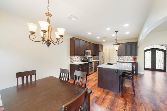 dining space with a chandelier, french doors, dark hardwood / wood-style floors, and sink