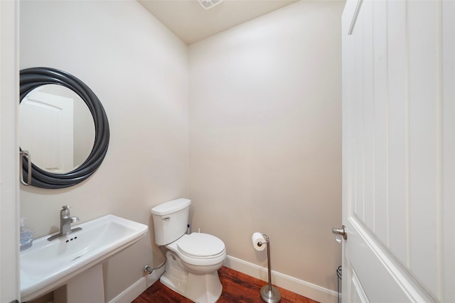 bathroom featuring hardwood / wood-style flooring, toilet, and sink